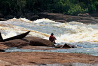 La contemplación del agua en movimiento es uno de los más antiguos placeres del hombre. Indígena en el raudal Kualet, río Inírida.