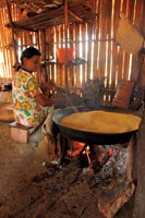 Las comunidades aisladas de la Amazonia y la Orinoquia colombianas se pueden beneficiar de la fuerza del agua en los raudales, donde es posible construir pequeñas centrales hidroeléctricas sin alterar el ambiente. Mujer cocinando la yuca brava.